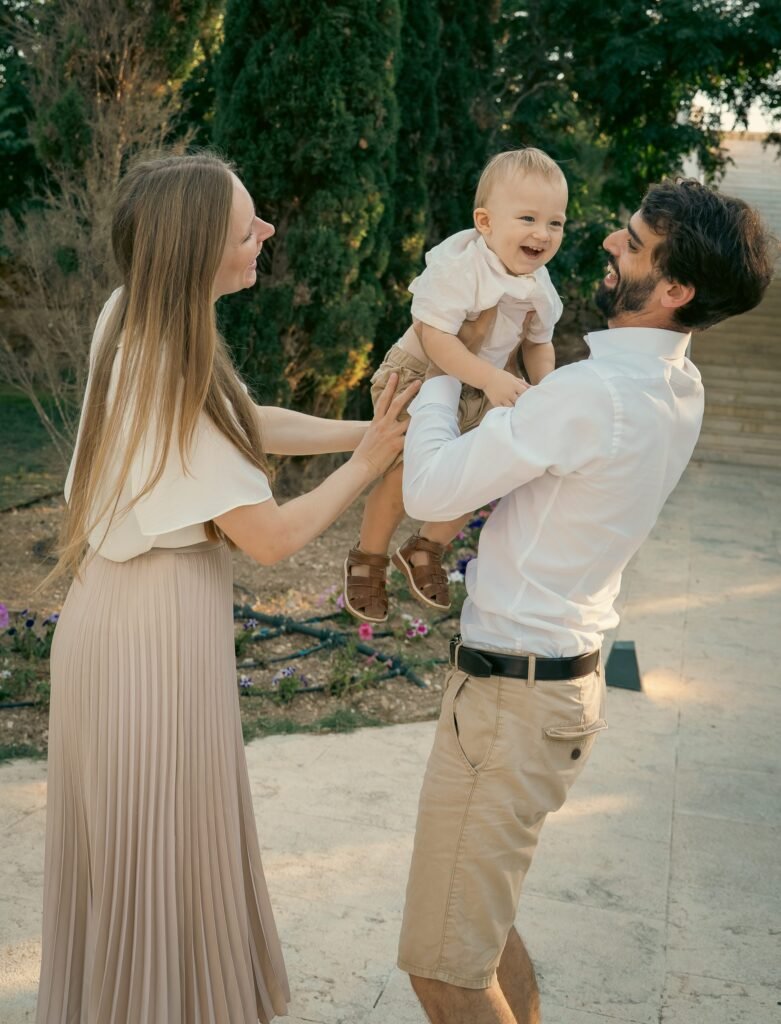 Father lifting his laughing toddler son into the air
